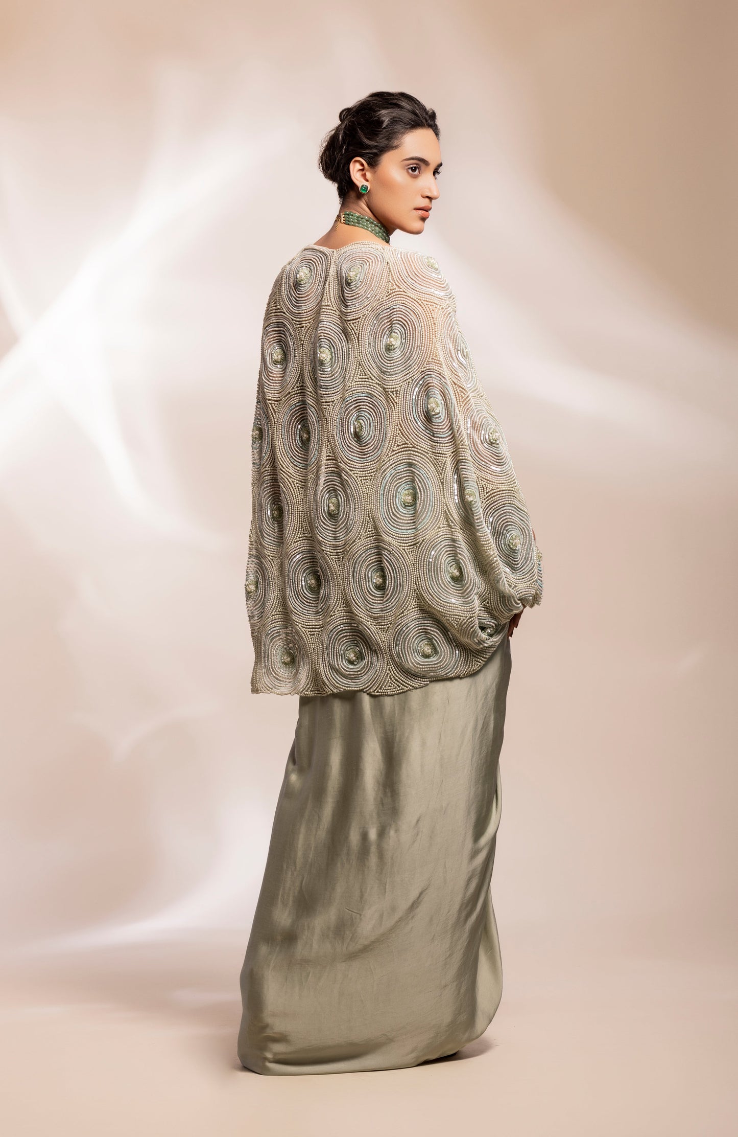 Cape with cut out sleeves with a bustier and drape lungi skirt