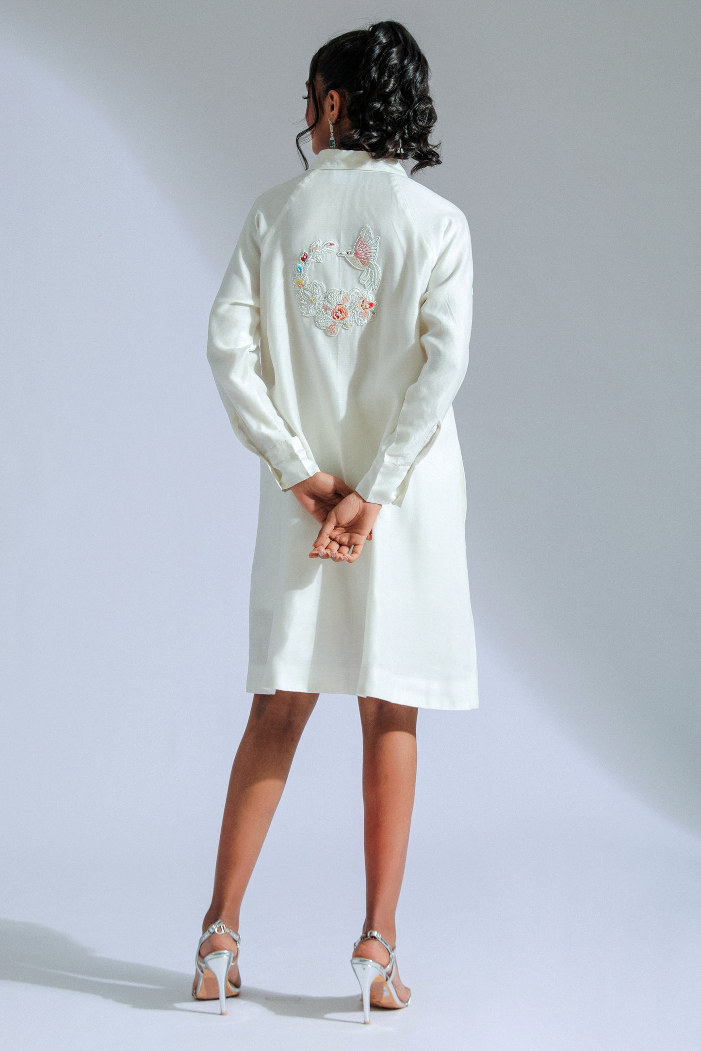 White shirt dress with intricate lace, beadwork, and charming motifs. 